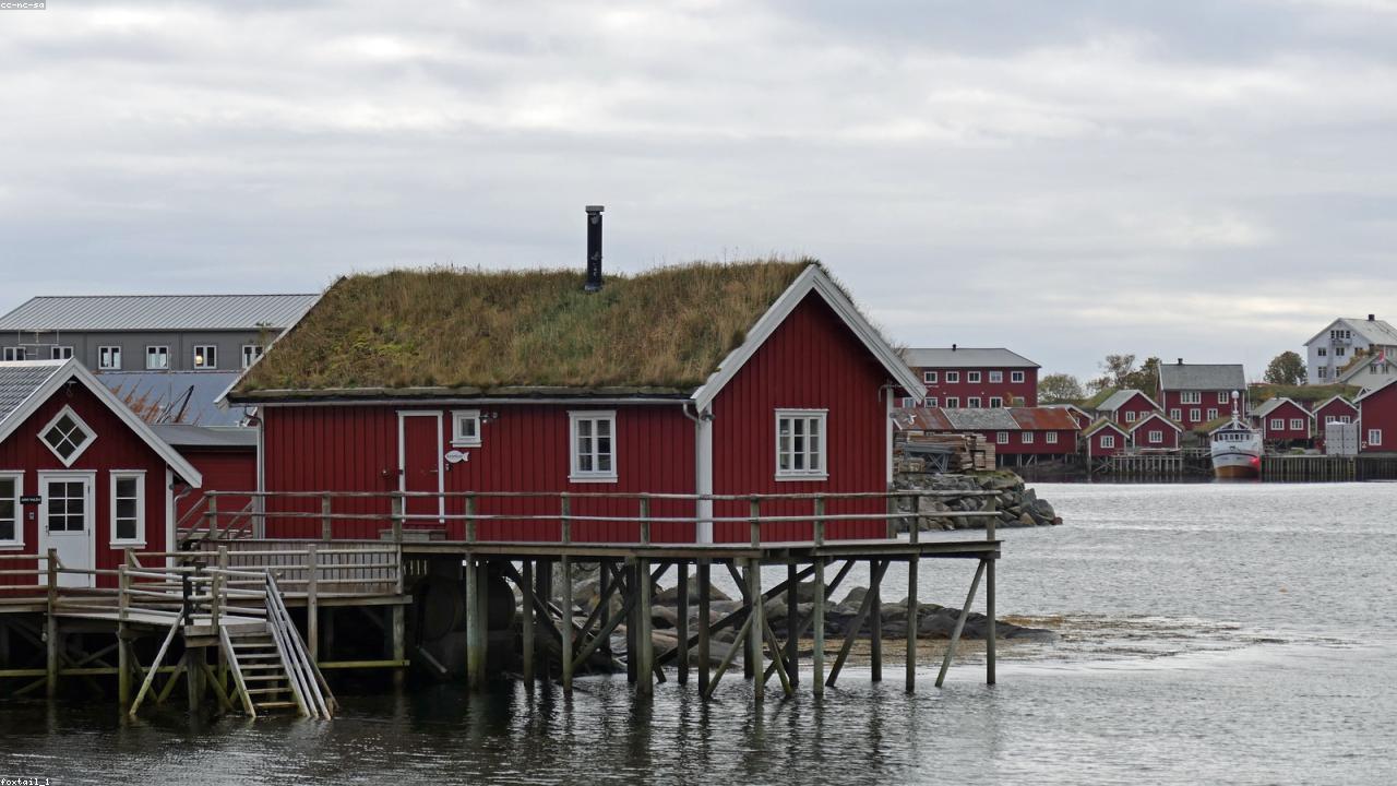 Red wooden cabins beneath the jagged peaks of Lofoten.